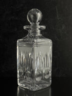 Clear glass decanter with a stopper on a black background