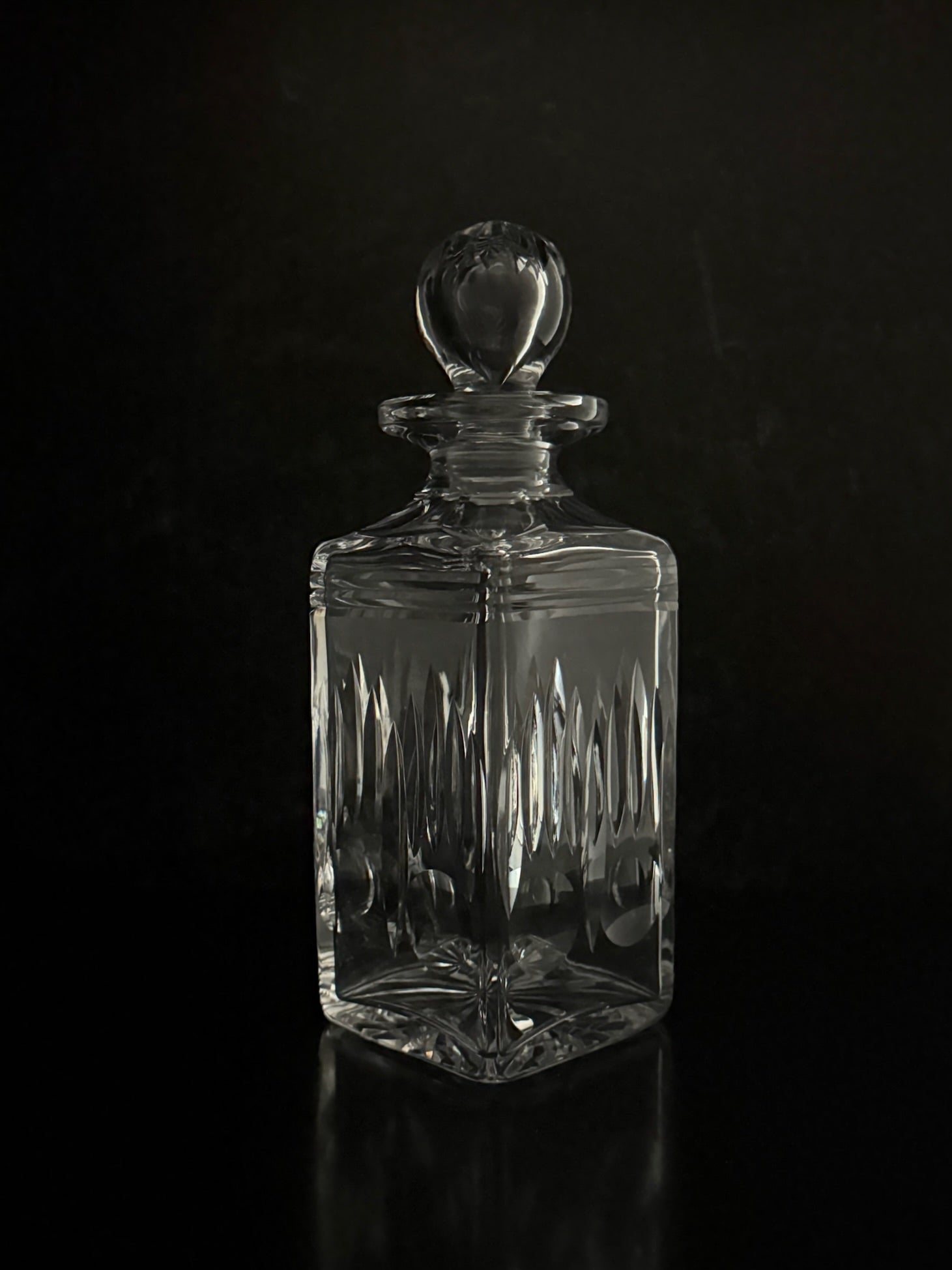 Clear glass decanter with a dark background