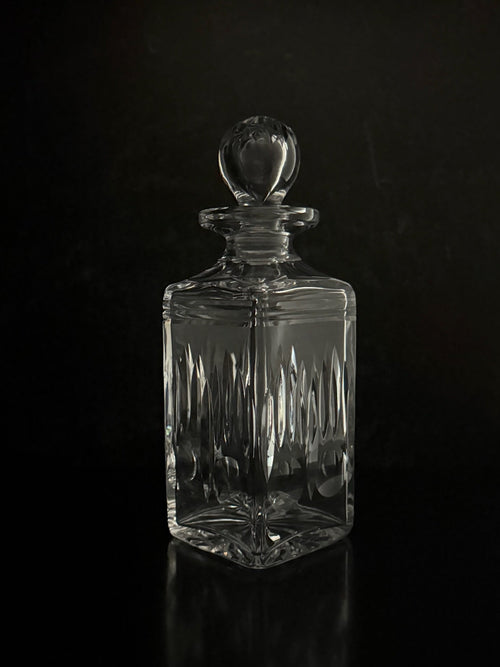 Clear glass decanter with a dark background
