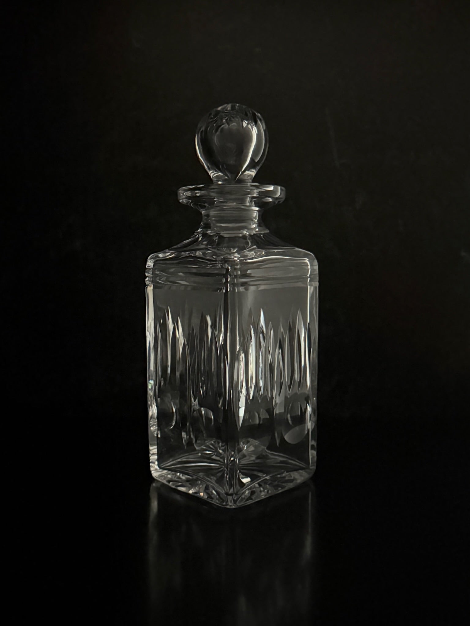 Clear glass decanter with a dark background