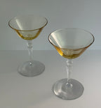 Two topaz colored coupes with a clear stem, displayed on a light gray surface against a light gray background.
